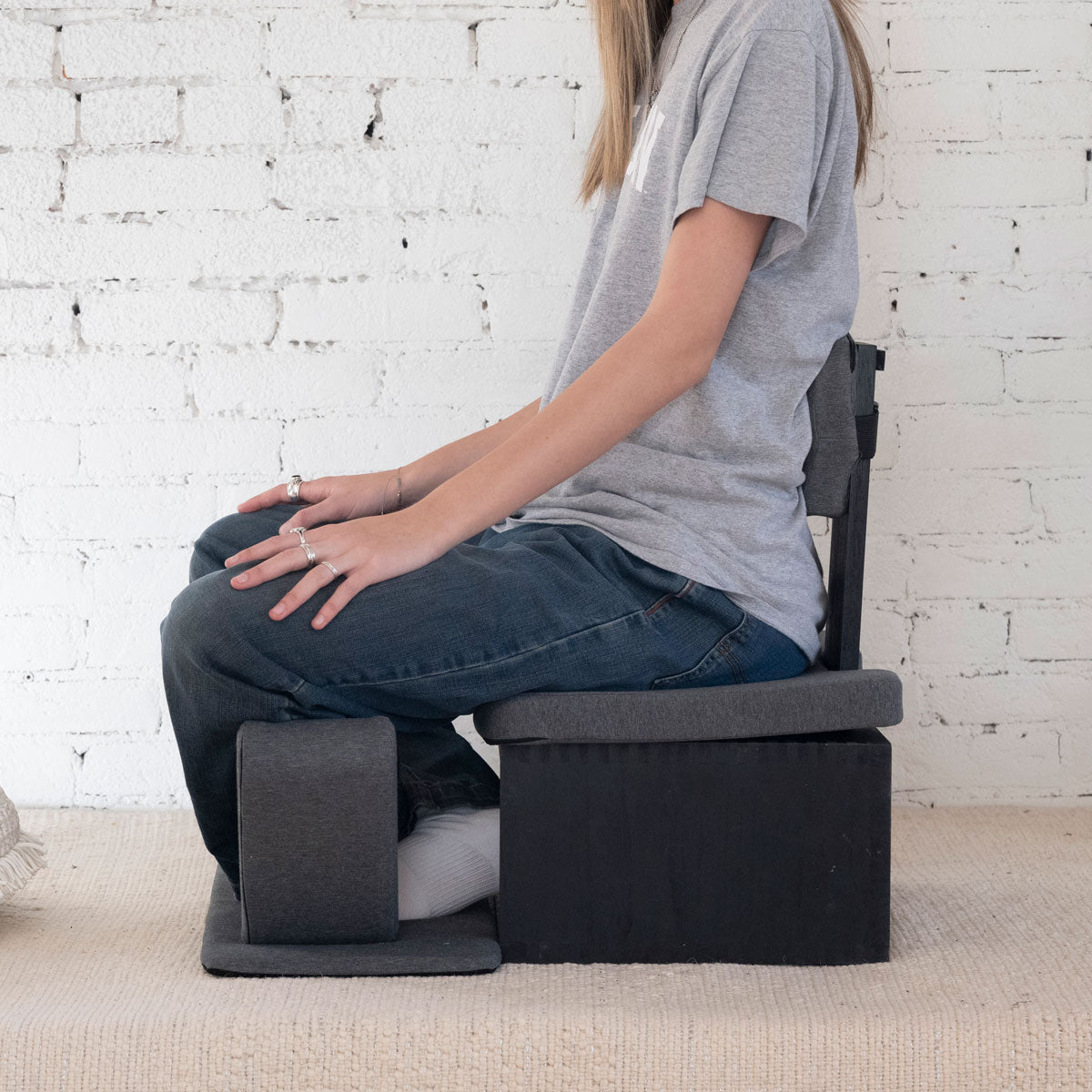 Black Ungloo Box portable meditation chair with back and hip support, shown in profile view.