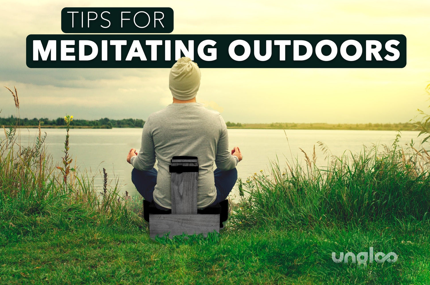 Image of man sitting on an ungloo box meditating outdoors by a lake